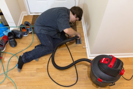 air duct cleaning worker using hose in vent